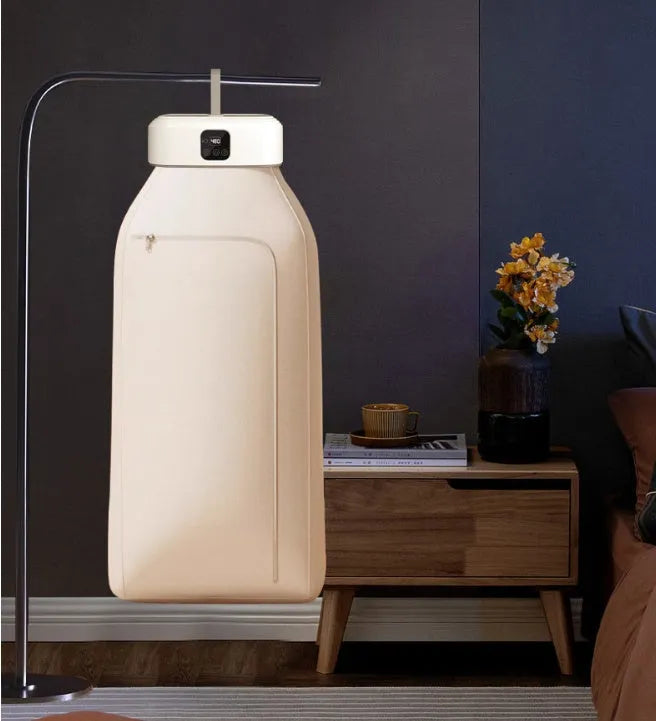White cylindrical portable laundry drier with remote control on flat surface