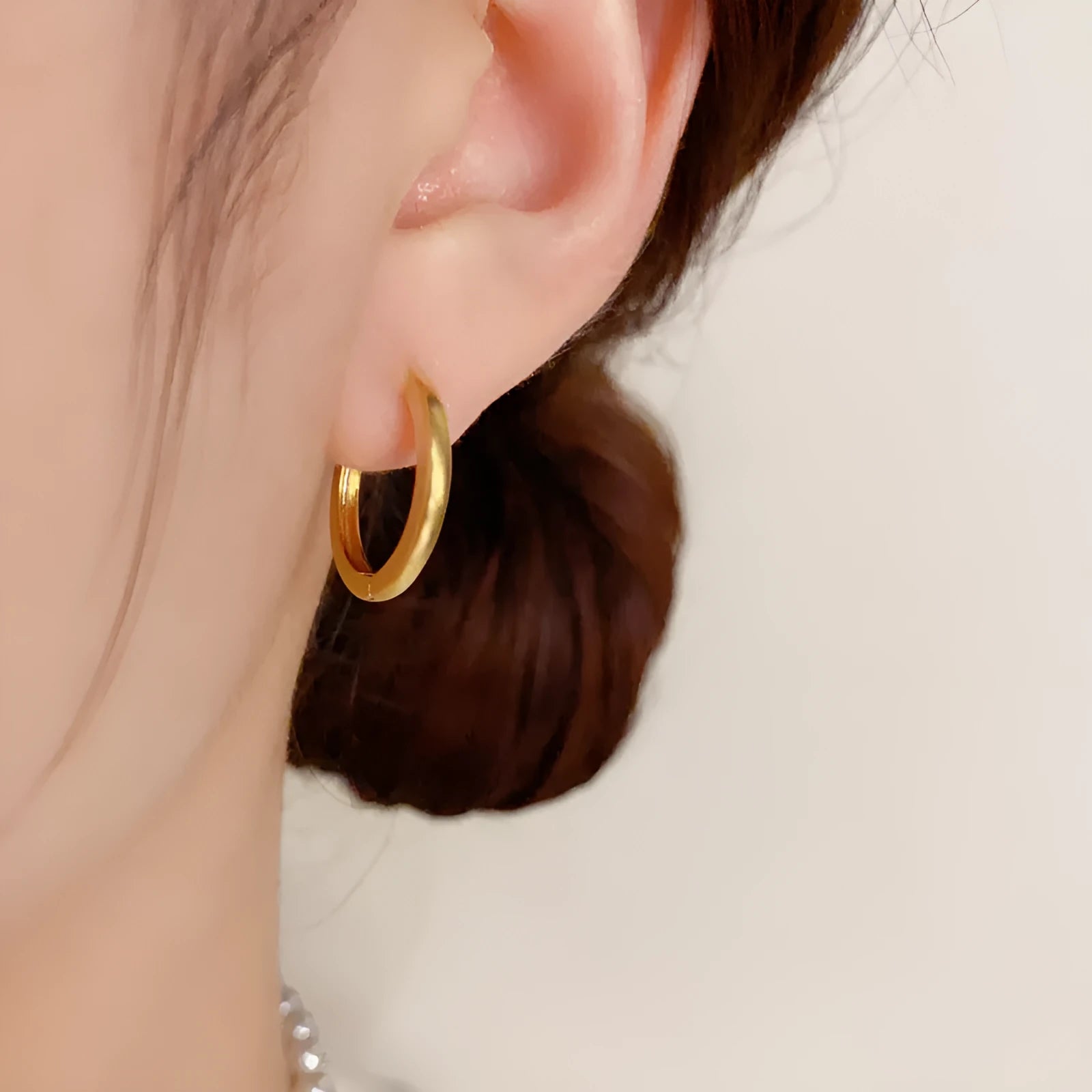 A pair of geometric round eyelet ear clips for women in gold or silver plating.