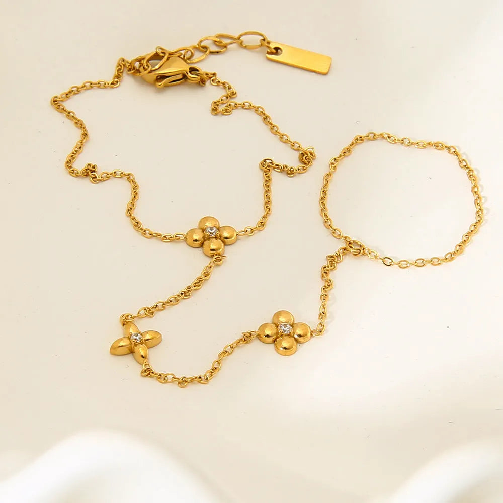 Gold stainless steel bracelet with eight pointed star and flower charms