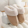 A pair of brown plush winter slippers with a round toe, flat heel, and non-slip PVC sole.