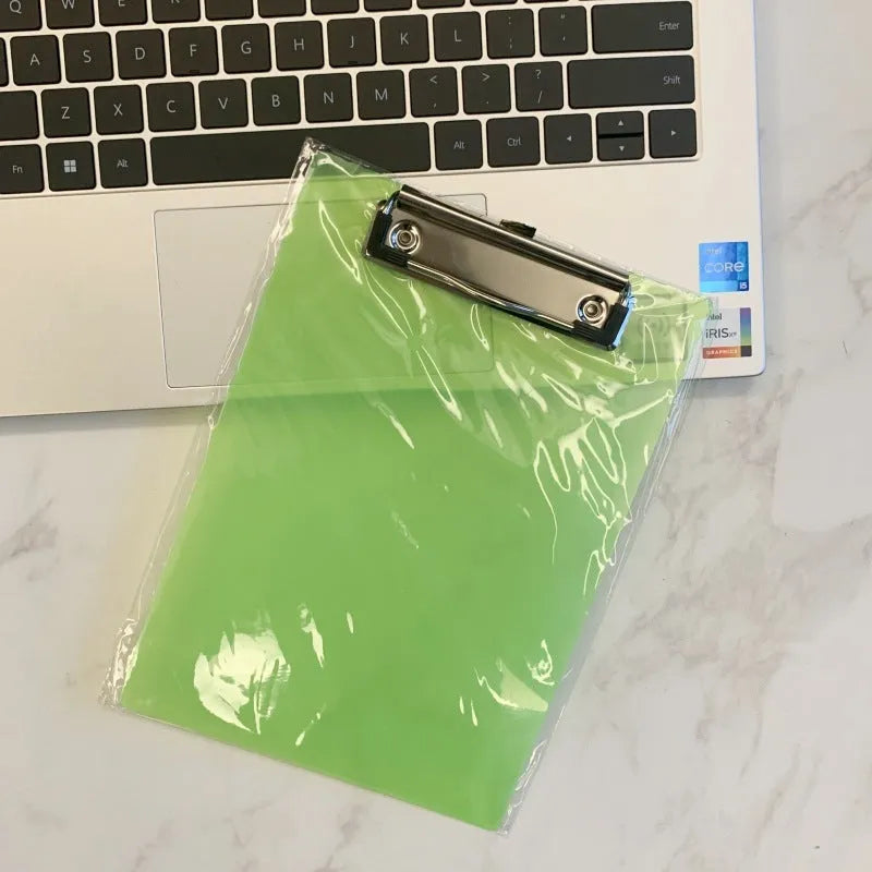 A4 transparent plate clipboard with metal clip, shown in blue colour on a desk with paper.