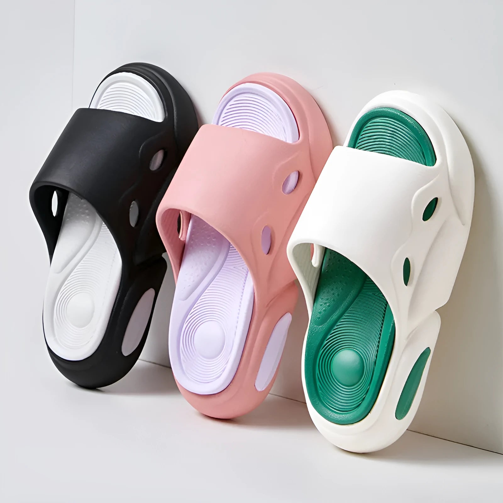 A pair of unisex EVA foam slippers with a thick sole and leather lining, shown in a two-colour design.