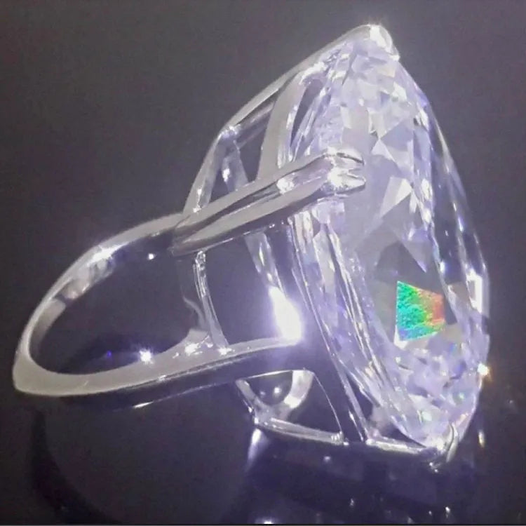 Women's simple white gold colour alloy ring with a square diamond inlay, shown on a finger.