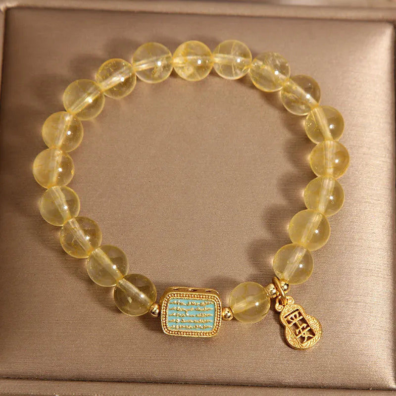 Women's citrine yellow crystal bracelet with rhinestone detailing on a wrist