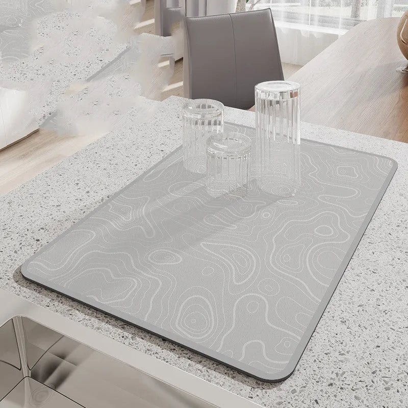 Square diatomite kitchen draining mat in camellia purple on a kitchen worktop, with a teacup resting on it