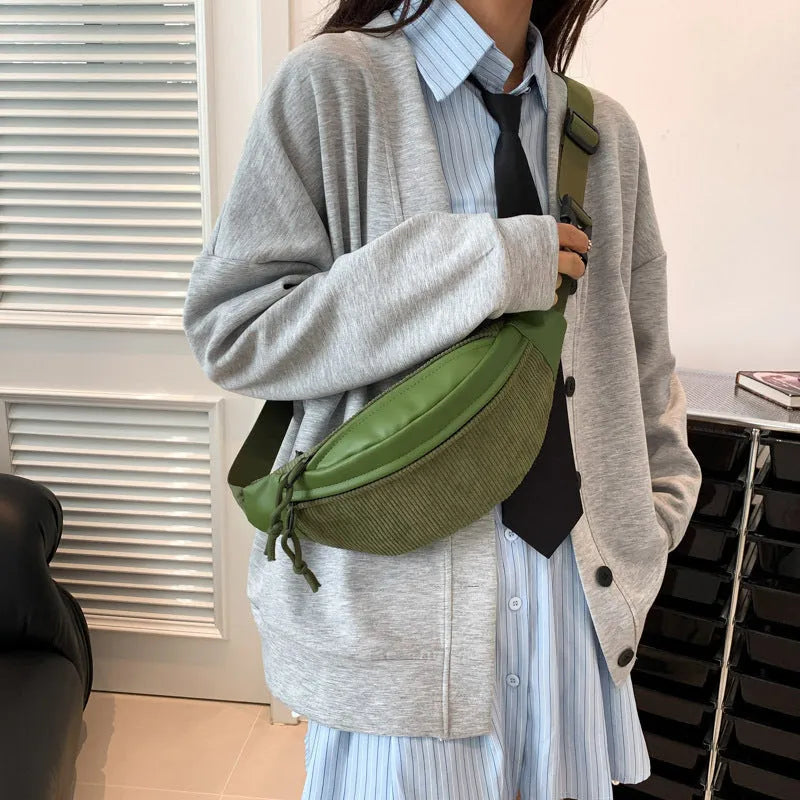 Corduroy crossbody bag in oval shape with brown colour, slit outer pocket, and crossbody strap for daily use