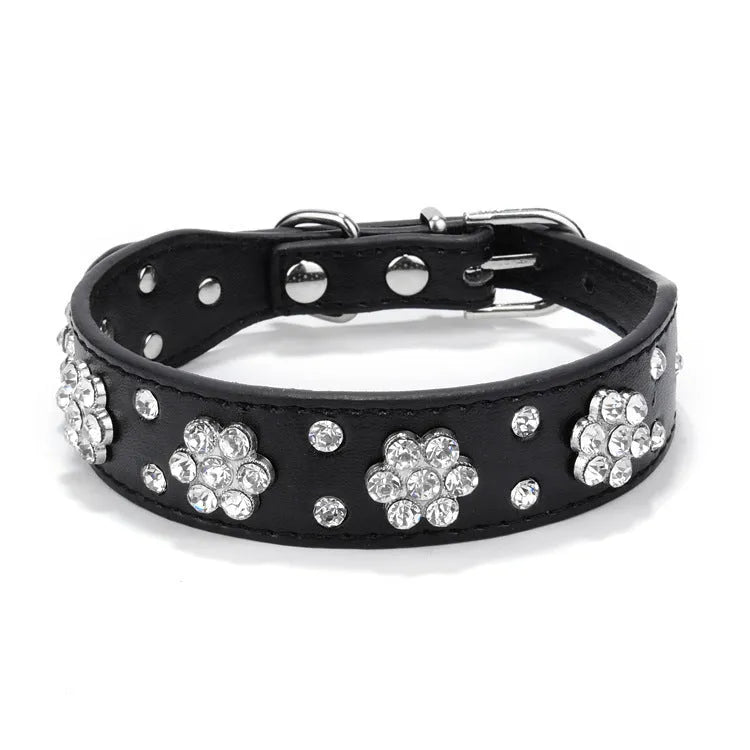 Close-up of a black PU leather dog collar with a sparkling rhinestone flower pattern and silver studs.