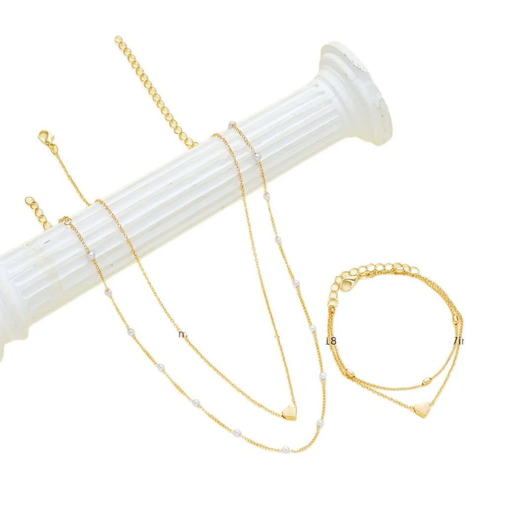 Double-layer stacked gold pearl heart necklace and bracelet jewelry set on display