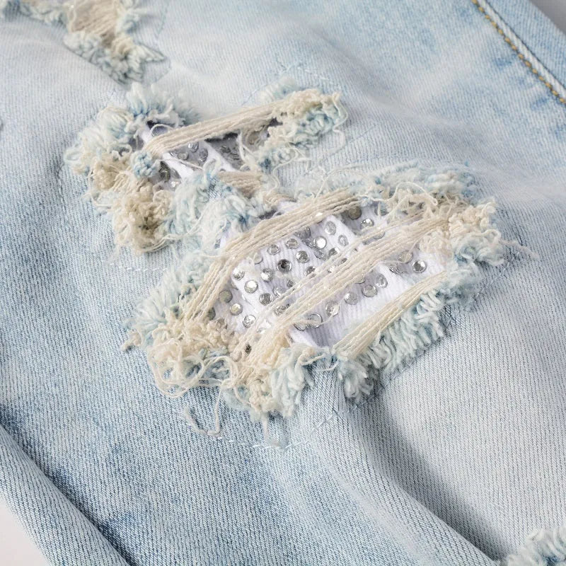 Light blue men's elastic slim fit jeans with hot diamond patch and whisker scrape detailing