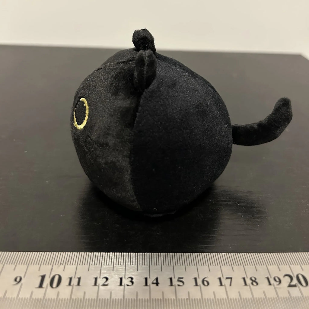 Fluffy black cat plush toy stuffed animal cushion on a sofa