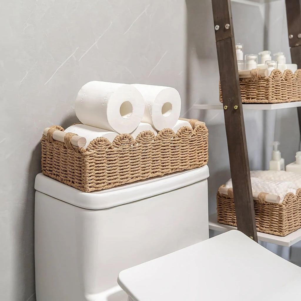 Modern woven rectangular storage basket in khaki colour on a wooden table holding remote controls and pens.