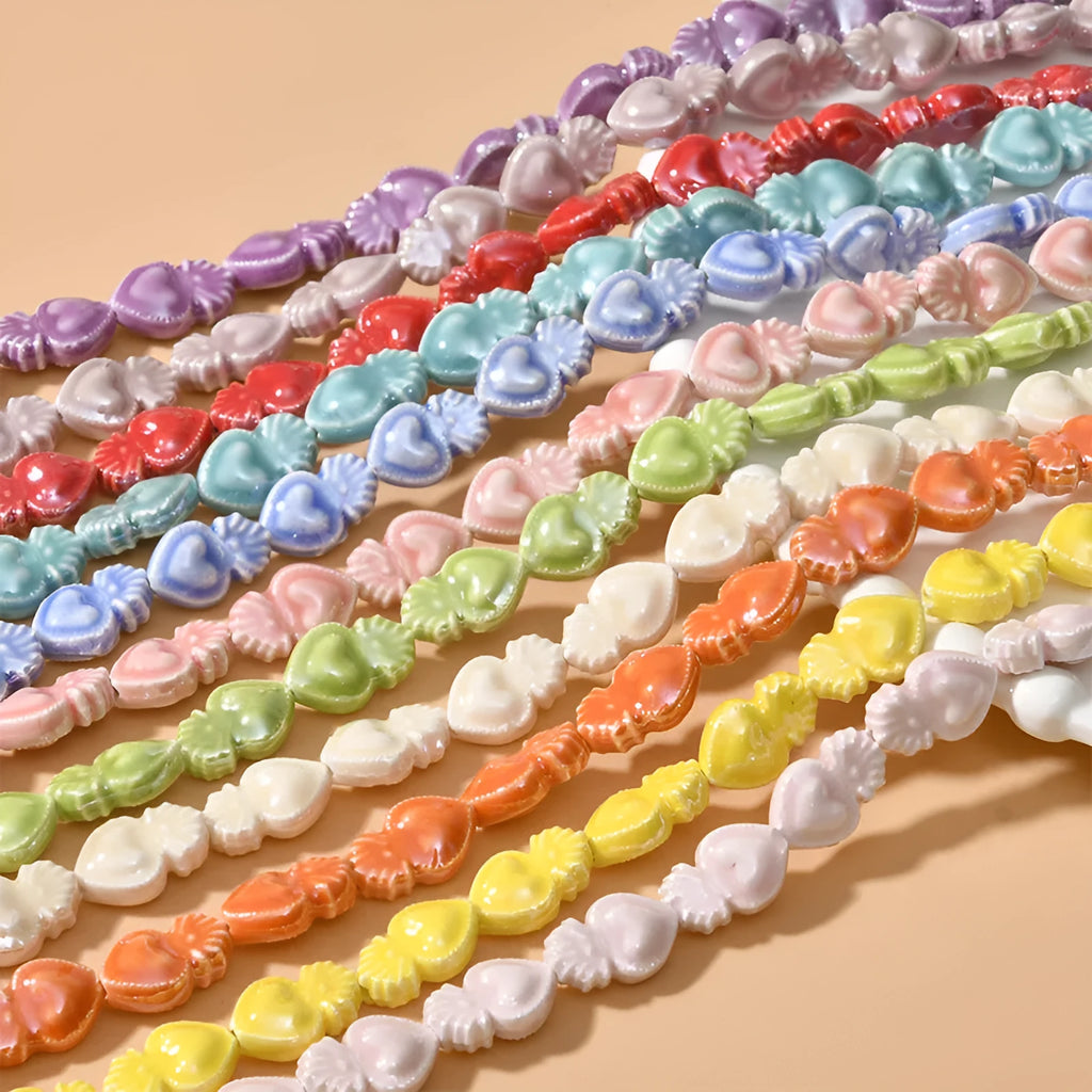Assorted small ceramic torch beads in multiple colours on a white background.
