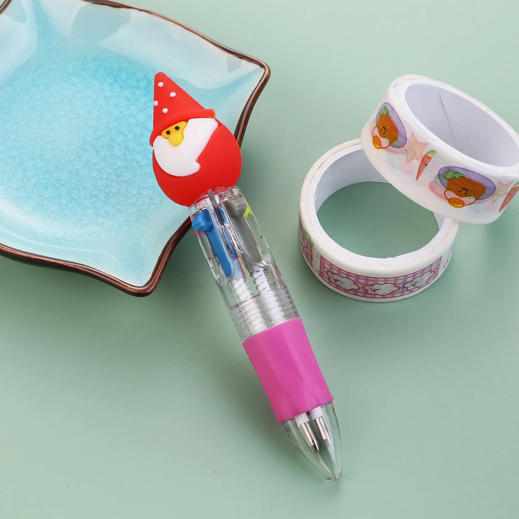 11cm long Christmas-themed four-colour ballpoint pen showing festive designs like reindeer and trees.