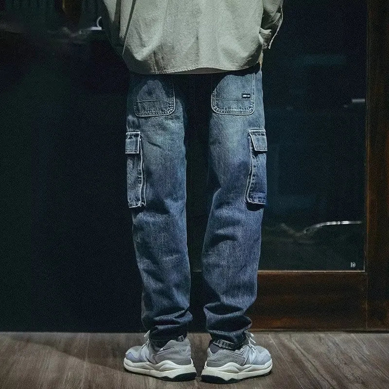 Blue men's loose straight-leg stretch jeans with a zip fly on a neutral background.