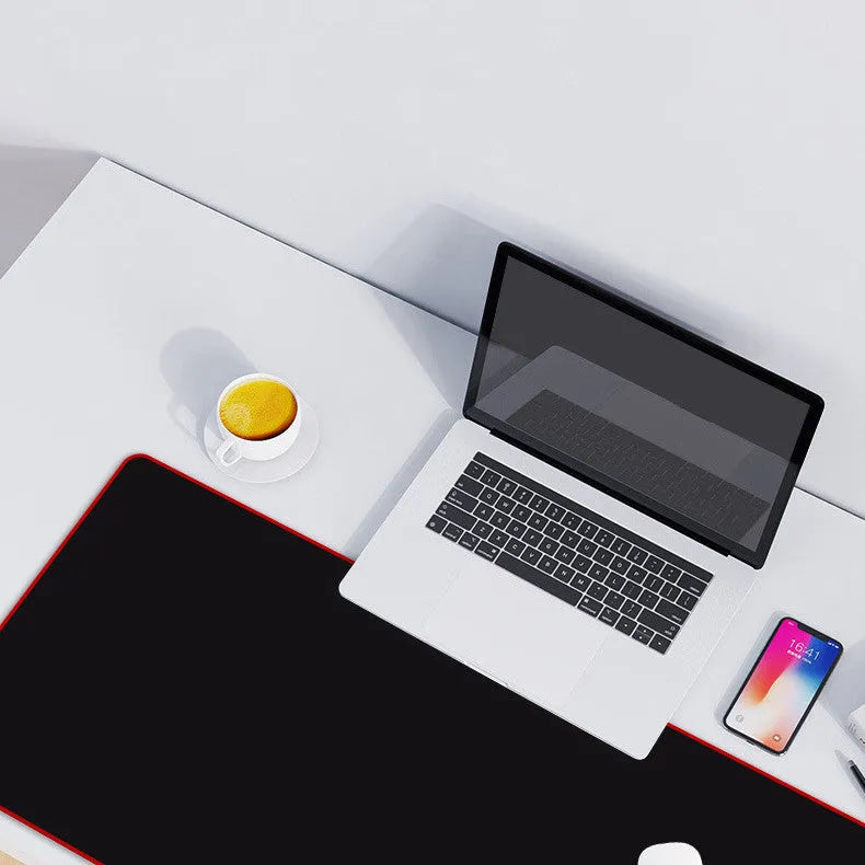 Solid colour black extra long overlock mouse pad on desk with keyboard and mouse