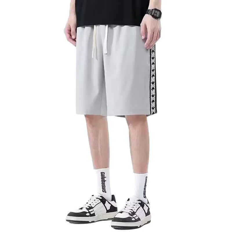 Men's black loose-fit track pants with elastic waistband and baggy leg silhouette