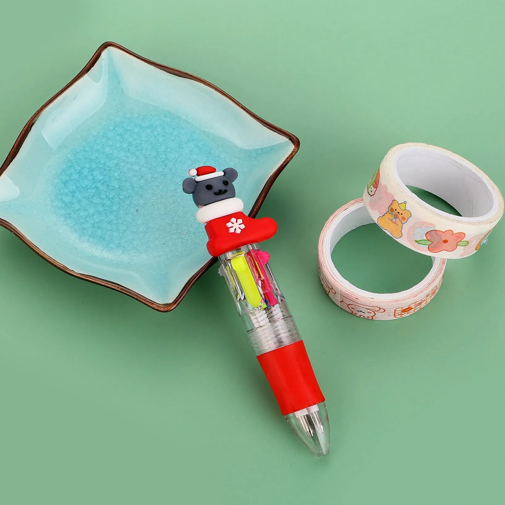 11cm long Christmas-themed four-colour ballpoint pen showing festive designs like reindeer and trees.