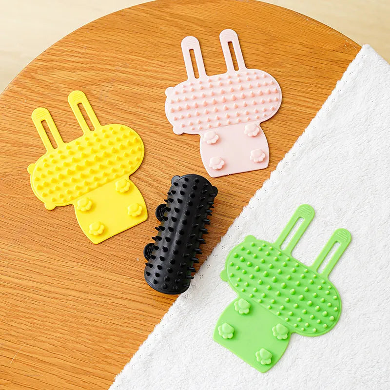 Adjustable silicone cat scratching brush mounted on table leg with rounded comb teeth for grooming