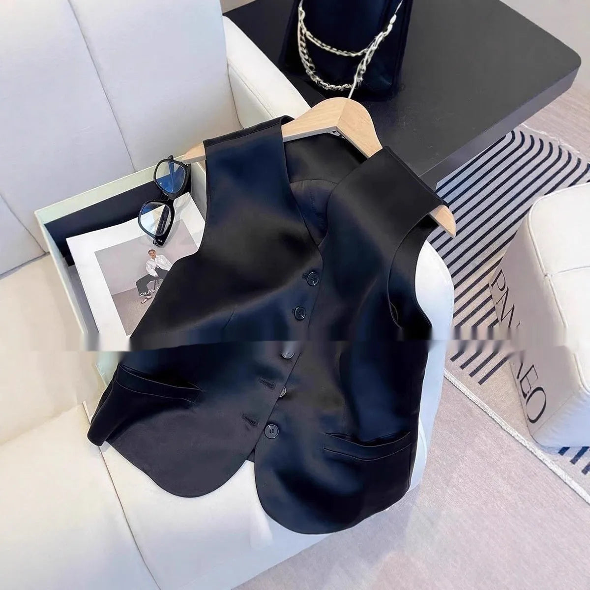Black satin ladies sleeveless vest with loose fit and normal length on hanger