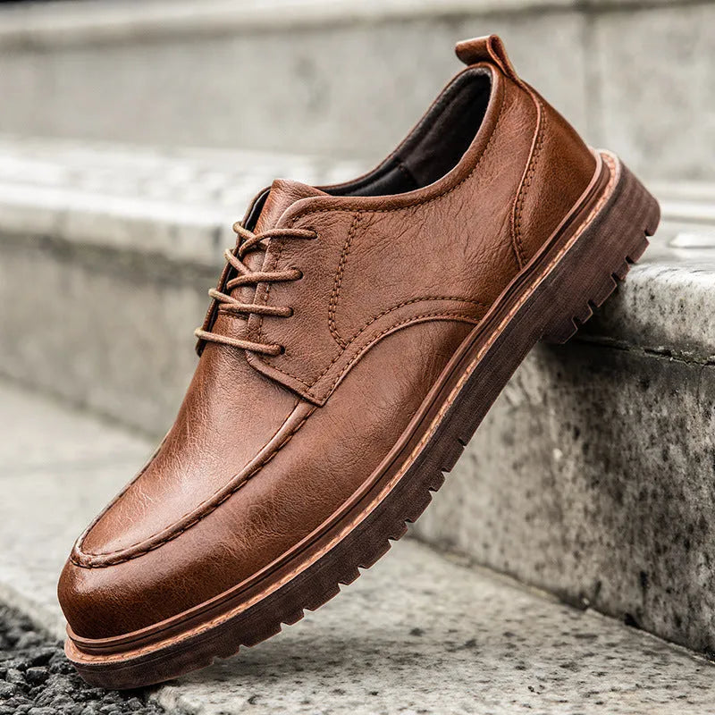 Men's black and brown casual leather slip-on shoes with round toe and visible sewing line detailing.
