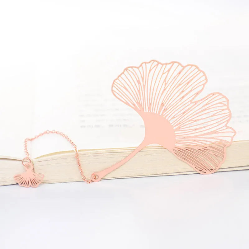 Brass metal bookmark with hollow leaf design and rose gold tassel in a presentation box.