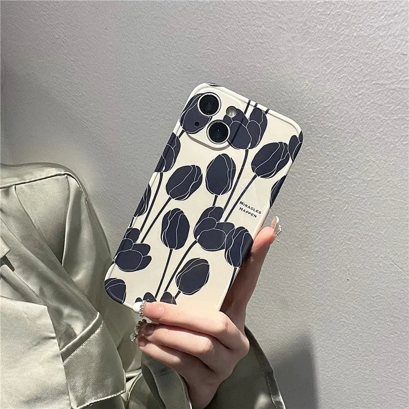Black silicone iPhone case with a printed white and grey tulip floral design on the back.