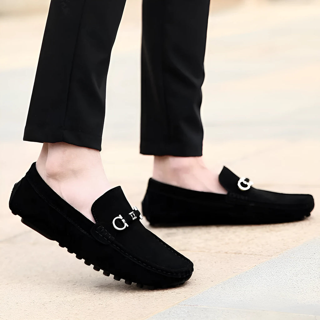 Men's black cowhide leather slip-on shoes with square toe and visible stitching on a rubber sole.