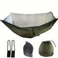 Outdoor camping automatic quick unfolding nylon hammock in camouflage colour with trees in background