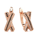 Pair of rose gold copper earrings with hollow-out X-shaped geometric design on light background