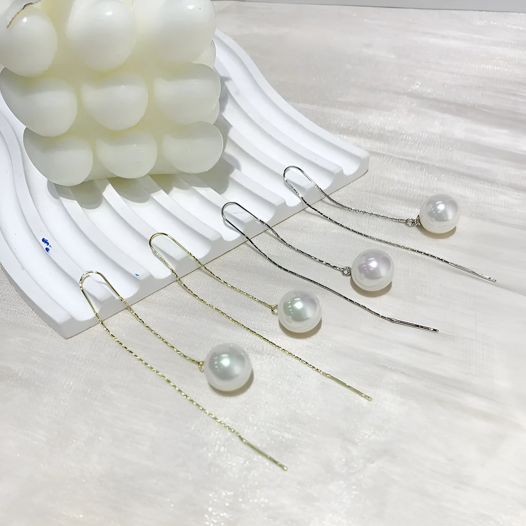 Fashionable long tassel pearl ear line drop earrings in gold finish on a white background