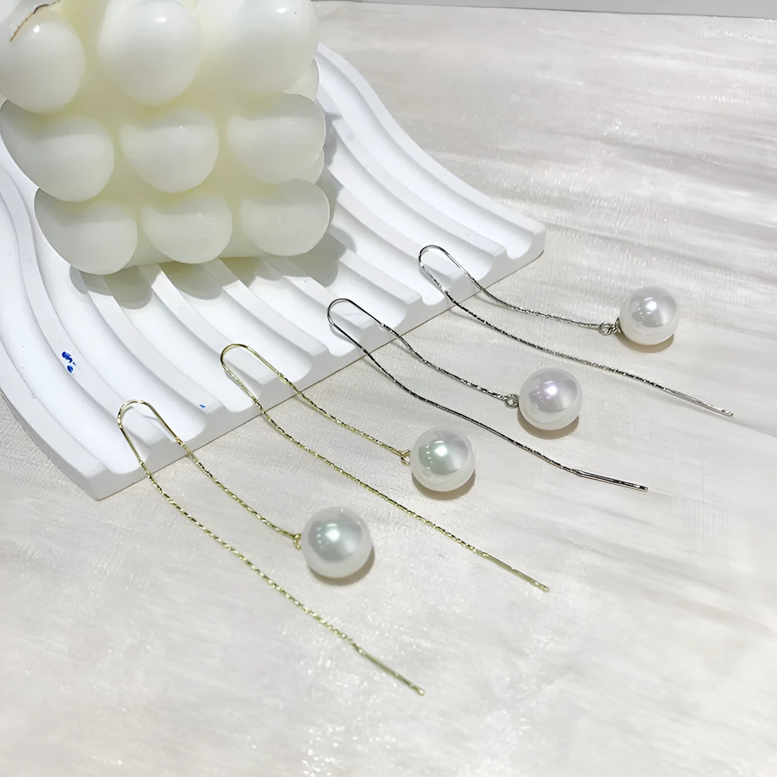Fashionable long tassel pearl ear line drop earrings in gold finish on a white background