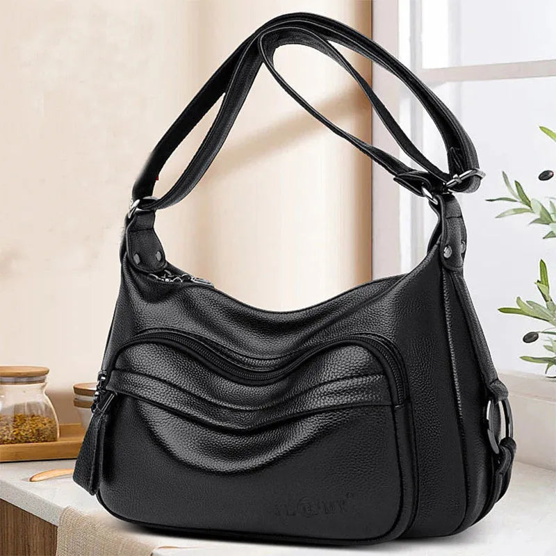 Large blue PU leather crossbody bag for women showing horizontal square shape and internal organiser pockets.