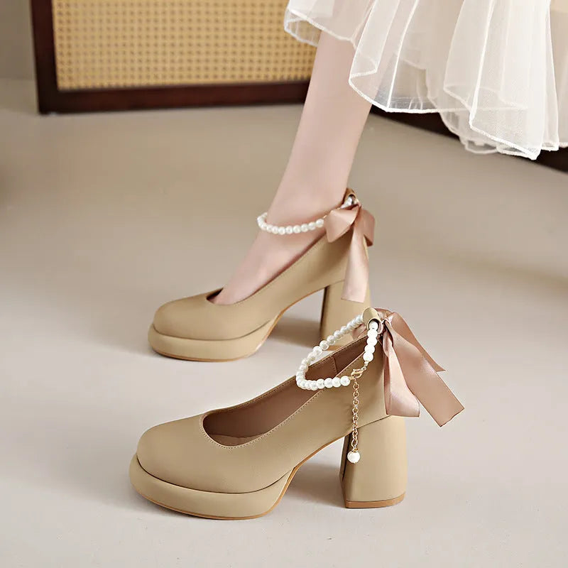 Women's beige Mary Jane shoes with chunky heel and ankle-strap buckle on a neutral background
