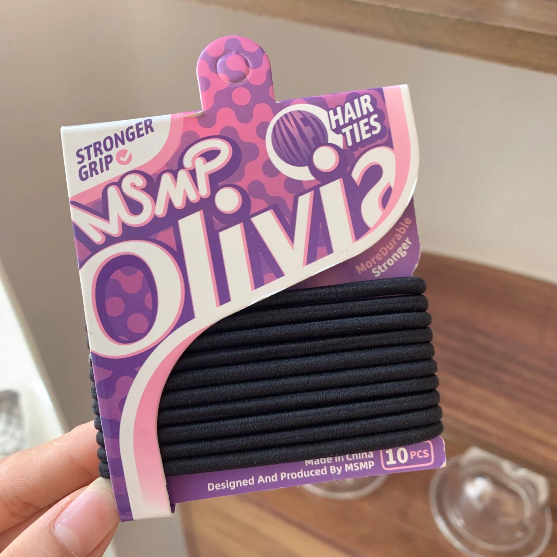 Assorted candy colour elastic hair bands with a braided design, shown holding a ponytail.