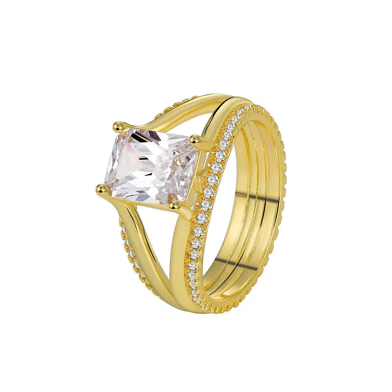 Gold-colour geometric women's ring with a square zircon centre, shown on a finger.