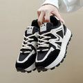 Women's flat-heel casual sports shoes in black with round toe and front lace-up design.