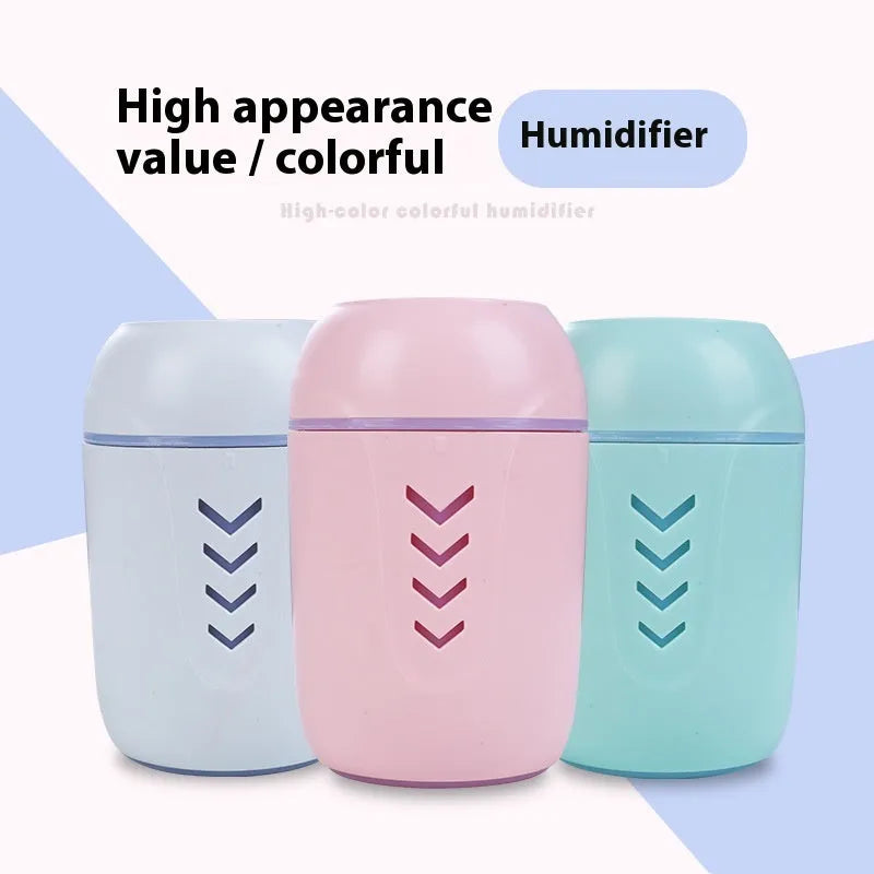Round white portable air purifier with USB cable on a wooden desk.