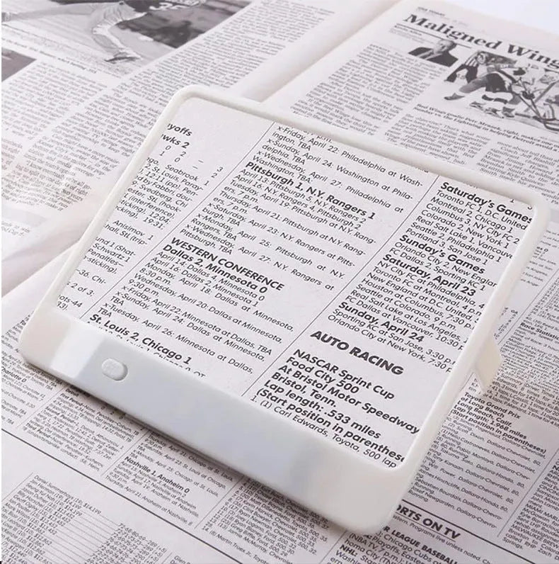 Black handheld 3x magnifying glass with built-in white LED light on a PVC handle.
