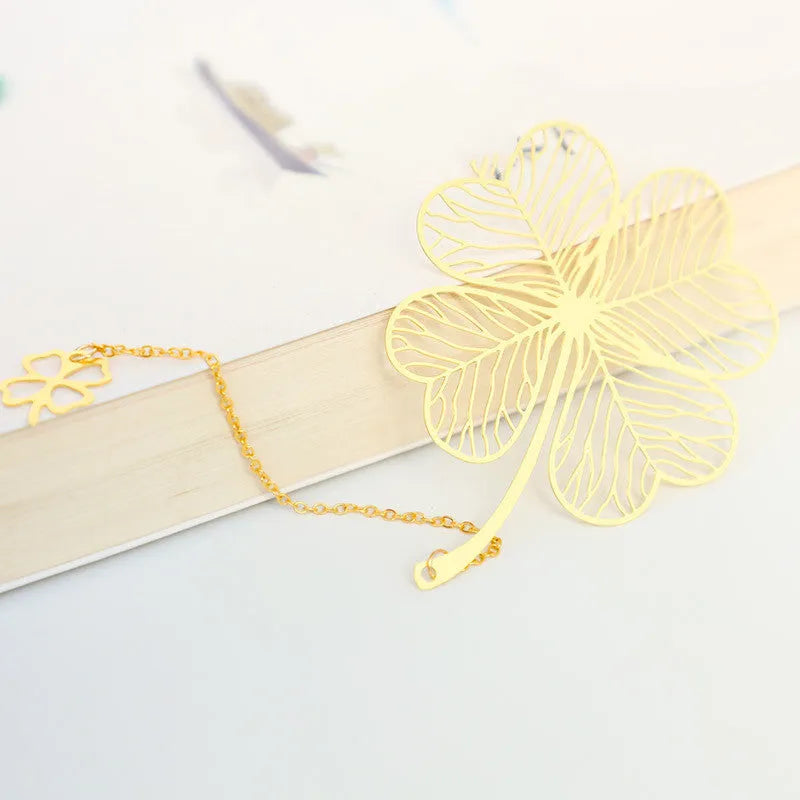 Brass metal bookmark with hollow leaf design and rose gold tassel in a presentation box.