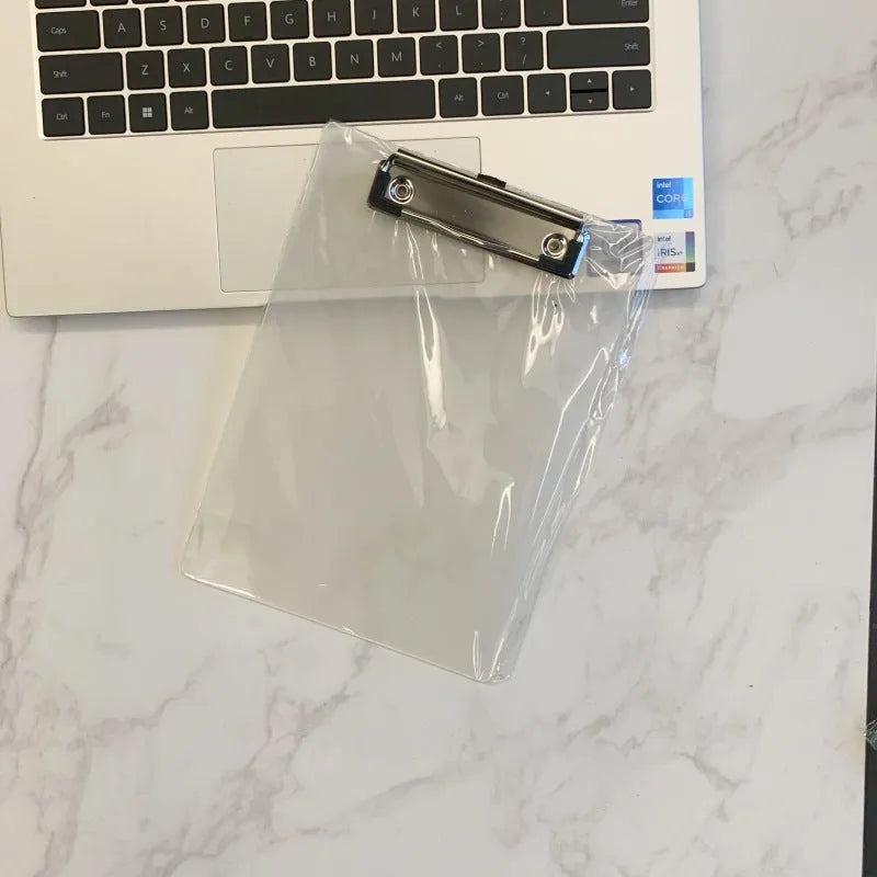 A4 transparent plate clipboard with metal clip, shown in blue colour on a desk with paper.