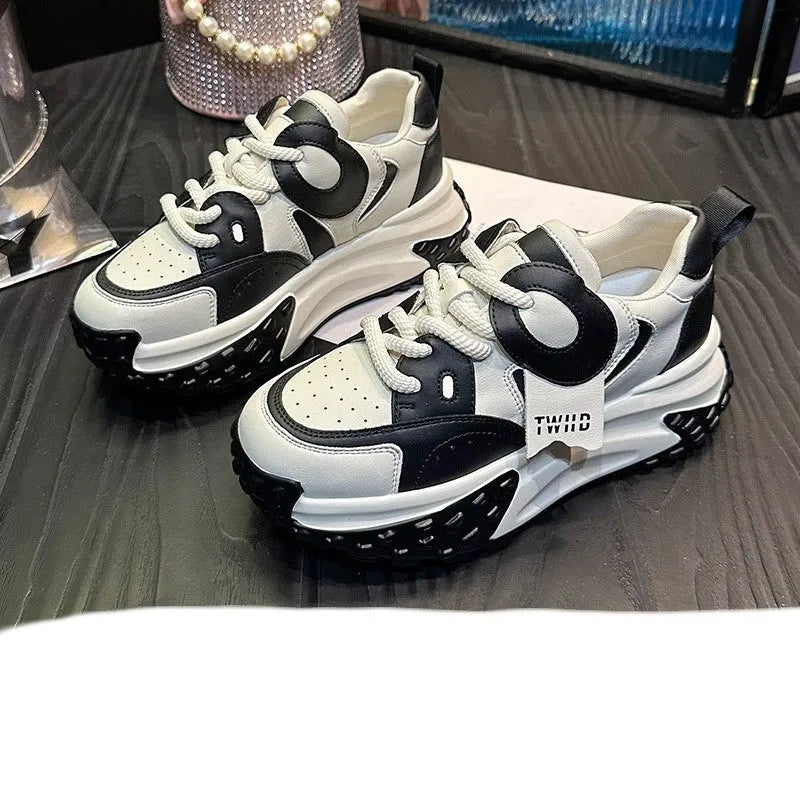 A pair of leather casual shoes with a thick wedge sole, round toe, and front lace-up design.