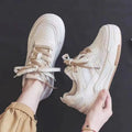 Beige and pink women's low top sneakers with a height increasing sole.