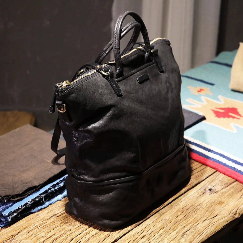 Black handmade vegetable tanned cowhide tote bag with zipper closure and large capacity for travel