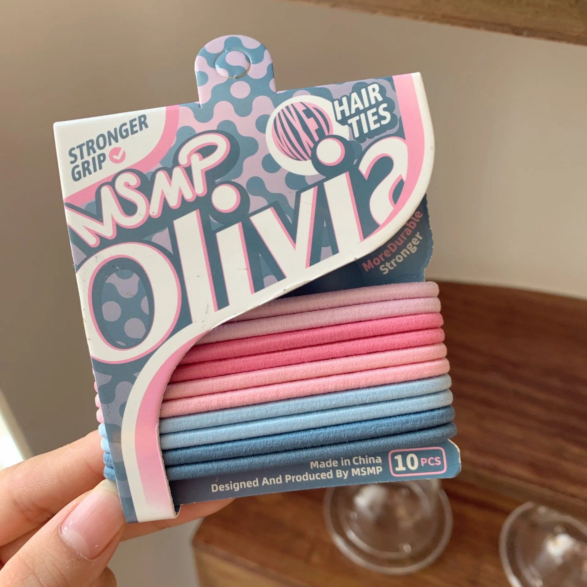 Assorted candy colour elastic hair bands with a braided design, shown holding a ponytail.