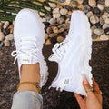 A pair of low-top Flyknit mesh casual trainers in a solid colour, featuring a platform sole and front lace-up closure.