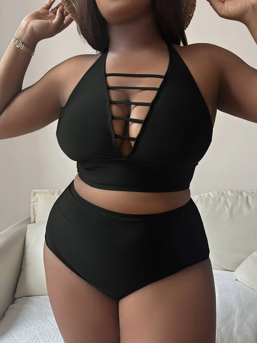 Plus size woman in a black halter bikini with cross shoulder straps and high-waisted briefs.