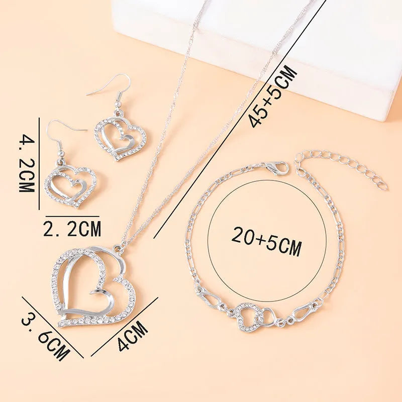 Silver romantic crystal heart jewelry set with bracelet necklace earrings on white background