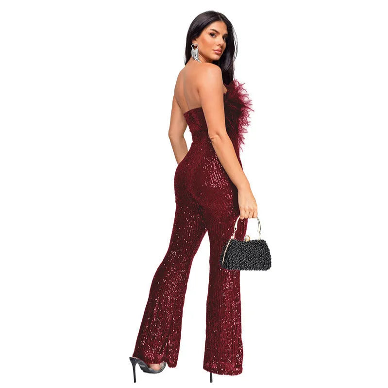 A woman wearing a sleeveless, backless black jumpsuit with flared legs.