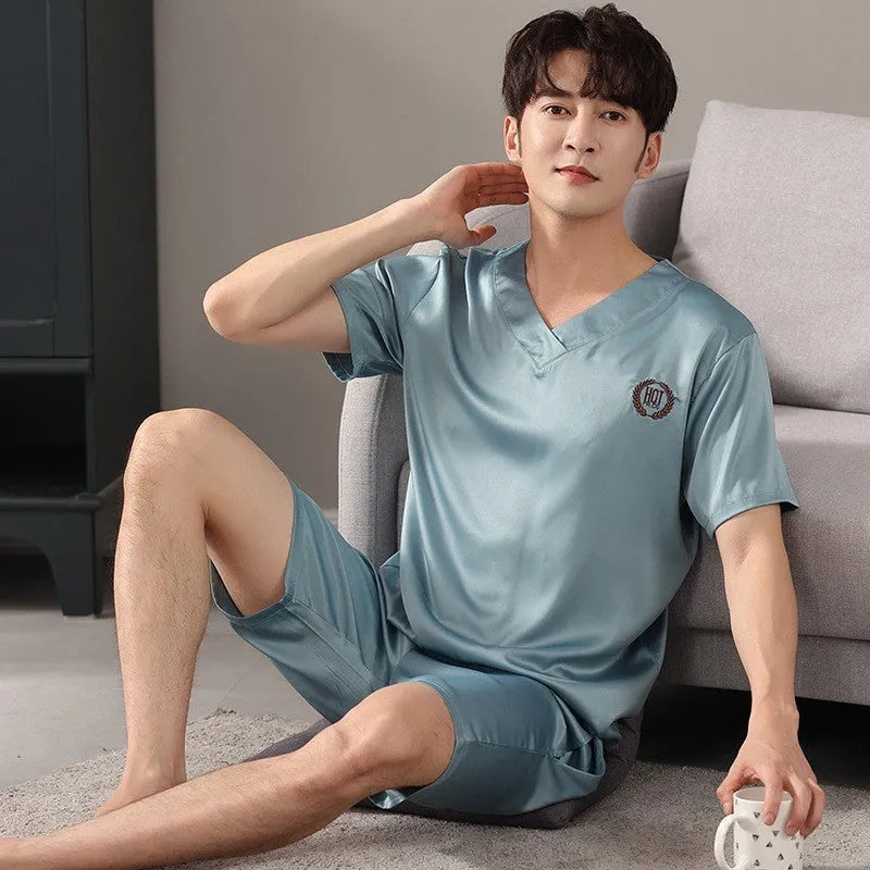 Man wearing a loose blue short-sleeved ice silk pyjama shirt and matching shorts.