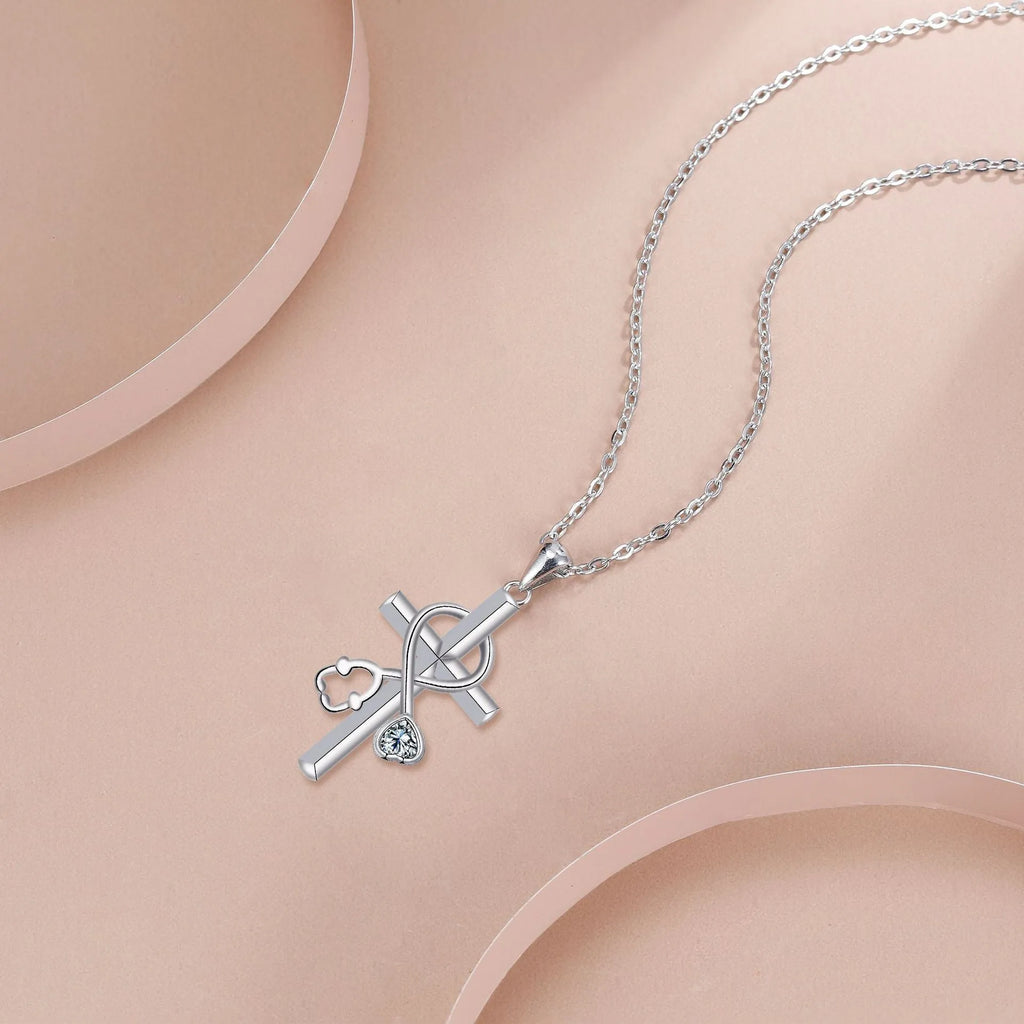 Copper cross necklace with a detailed stethoscope pendant on a chain.